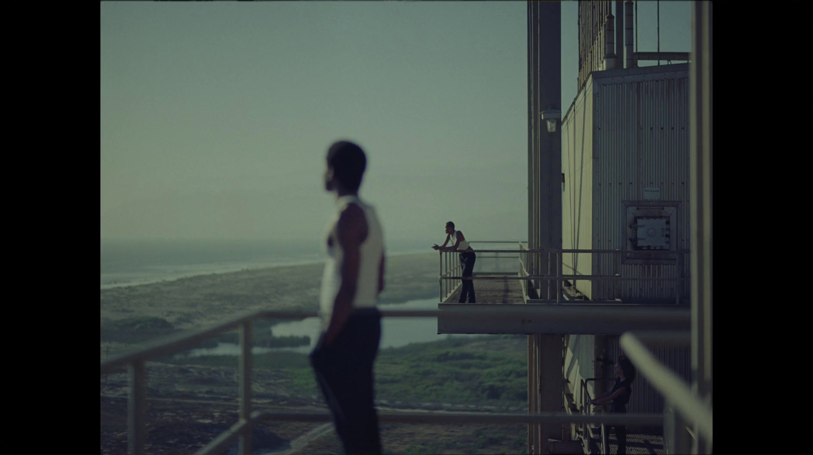 a person standing on a balcony overlooking a body of water