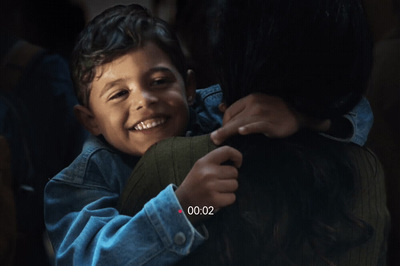 a young boy smiles as he hugs another child