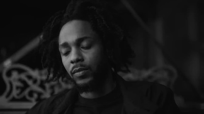 a man with dreadlocks sitting in a dark room