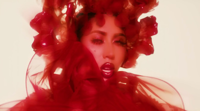 a woman in a red dress with red flowers on her head