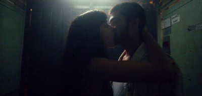 a man and a woman kissing in a dark room