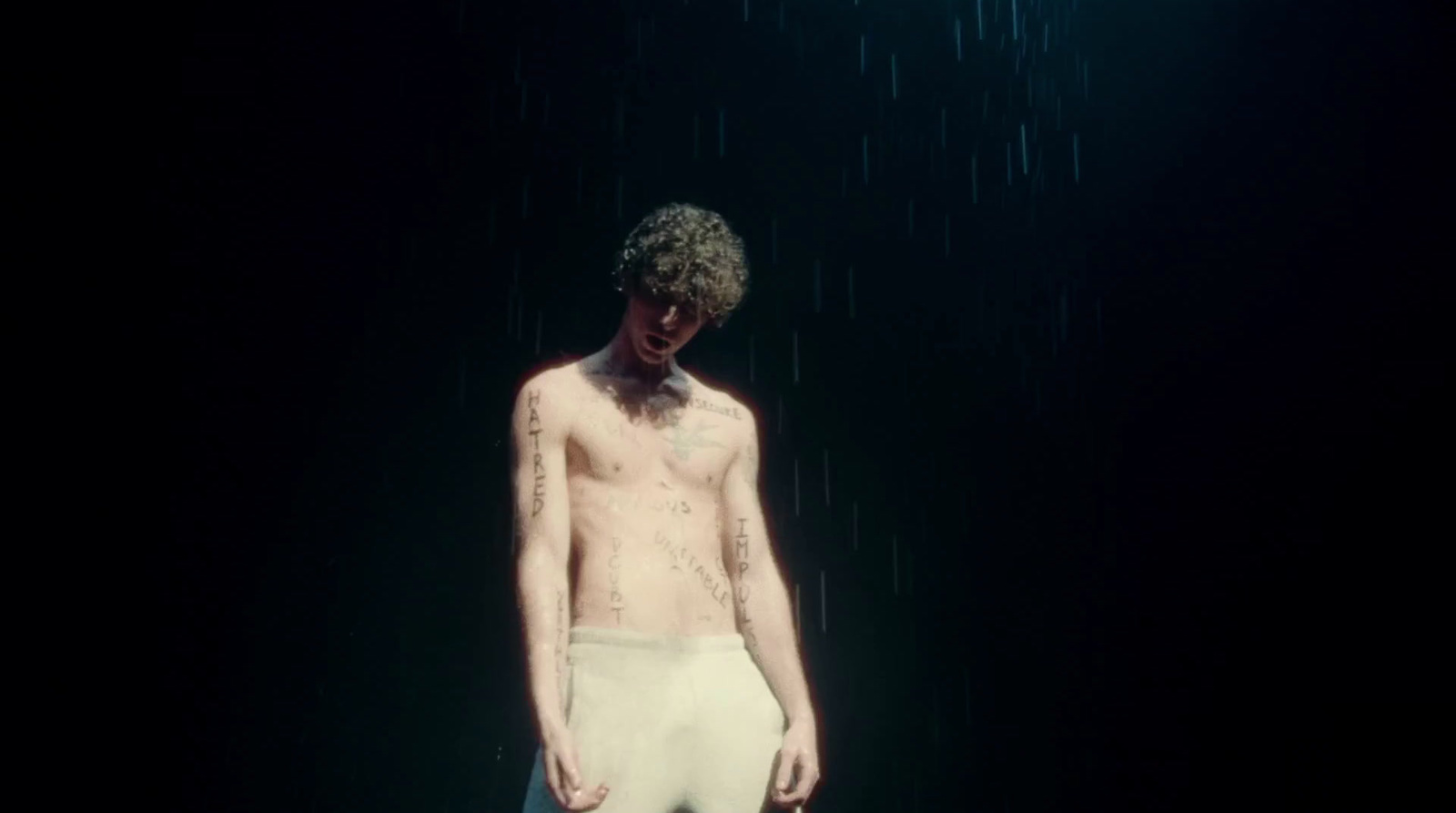 a man standing in the rain wearing white underwear