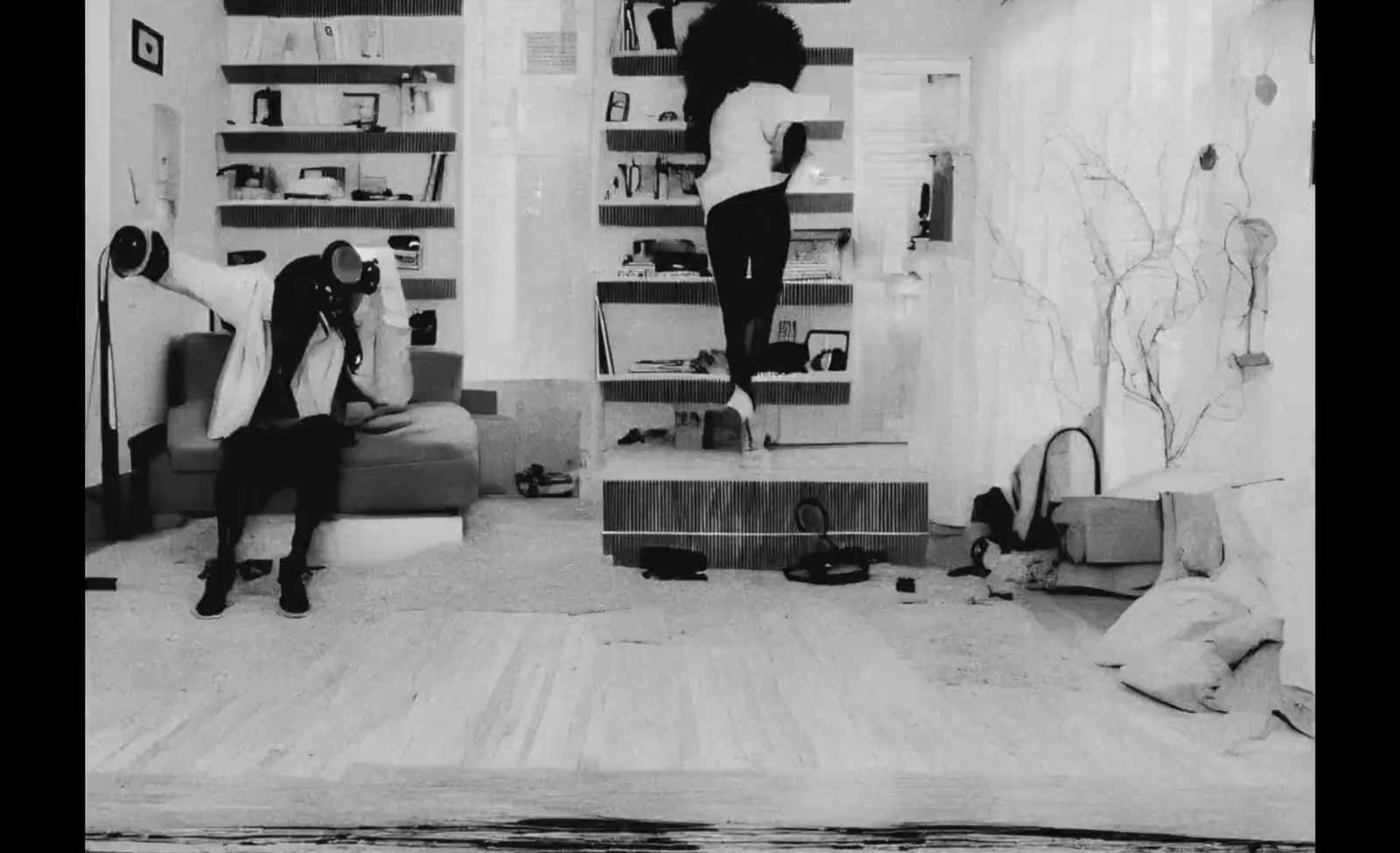 a black and white photo of two women in a living room