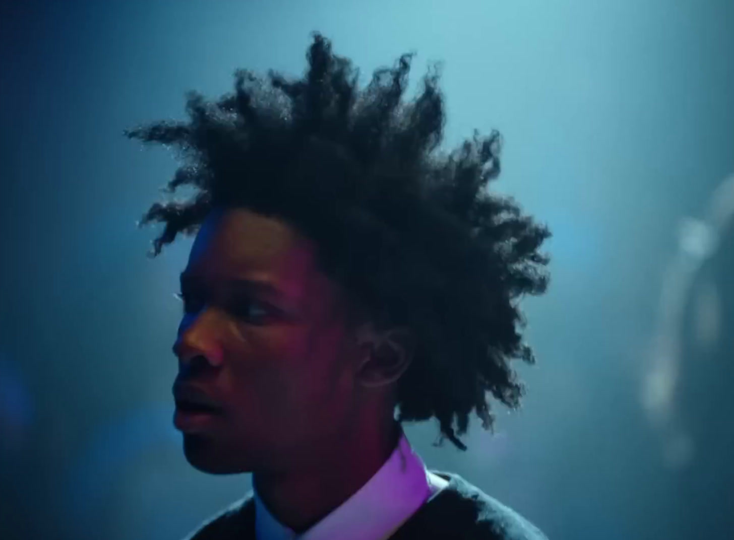 a woman with dreadlocks standing in a dark room