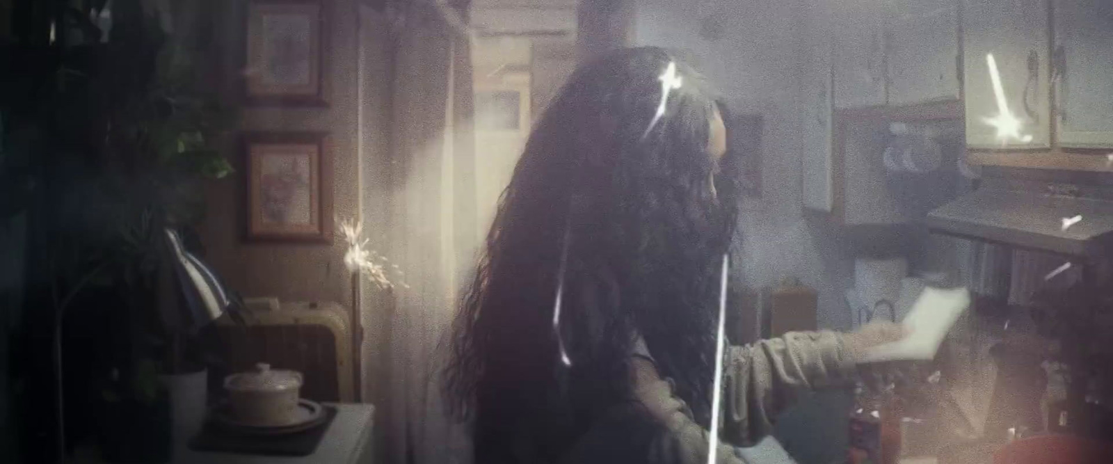 a woman with long hair standing in a kitchen