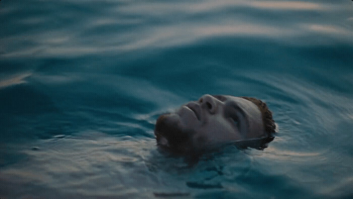 a man floating in the water with his head above the water