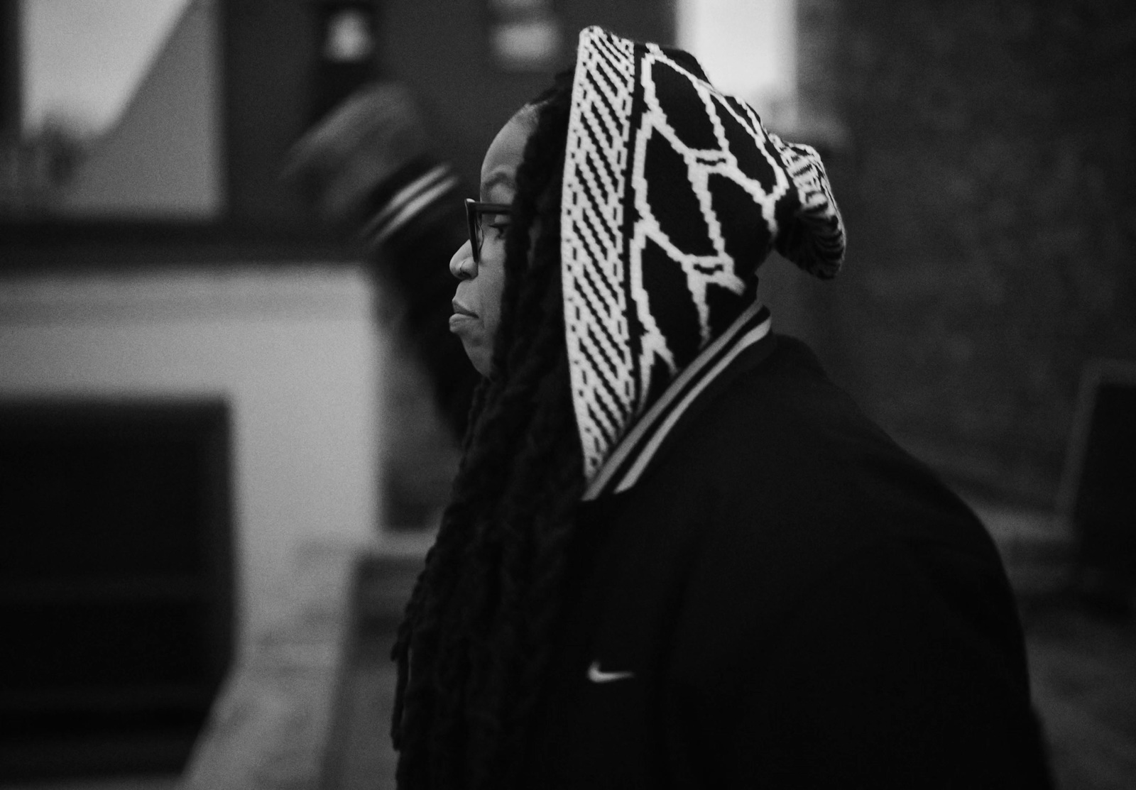 a black and white photo of a person wearing a hat