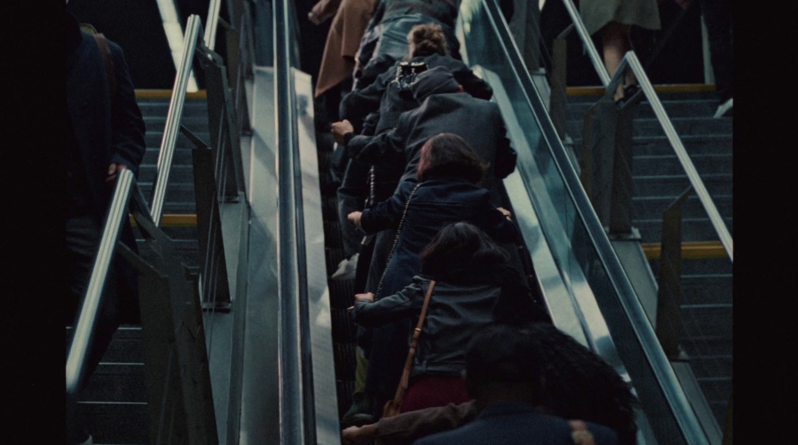 a group of people riding down an escalator