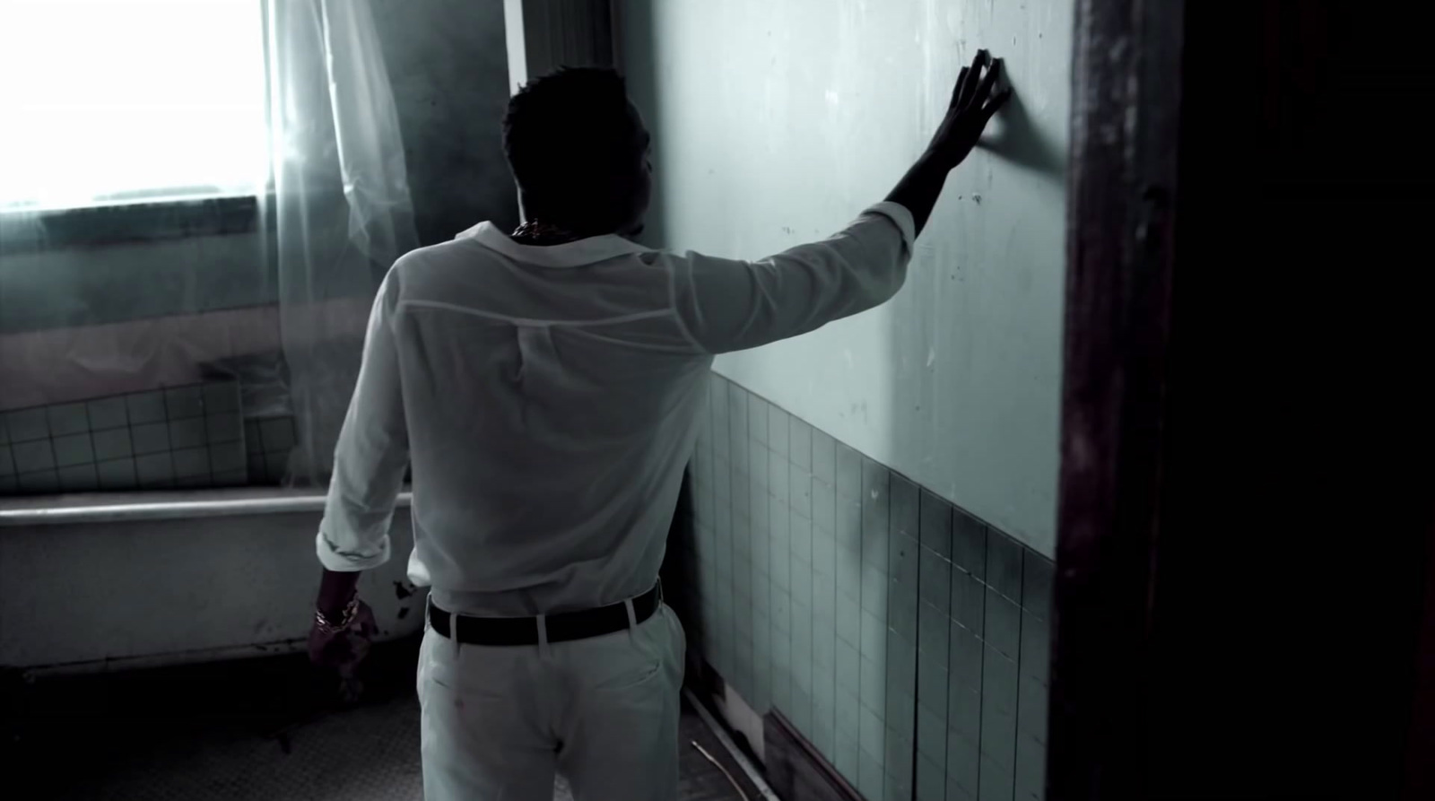 a man writing on a whiteboard in a dark room