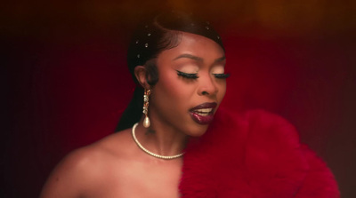 a woman in a red fur coat and pearls