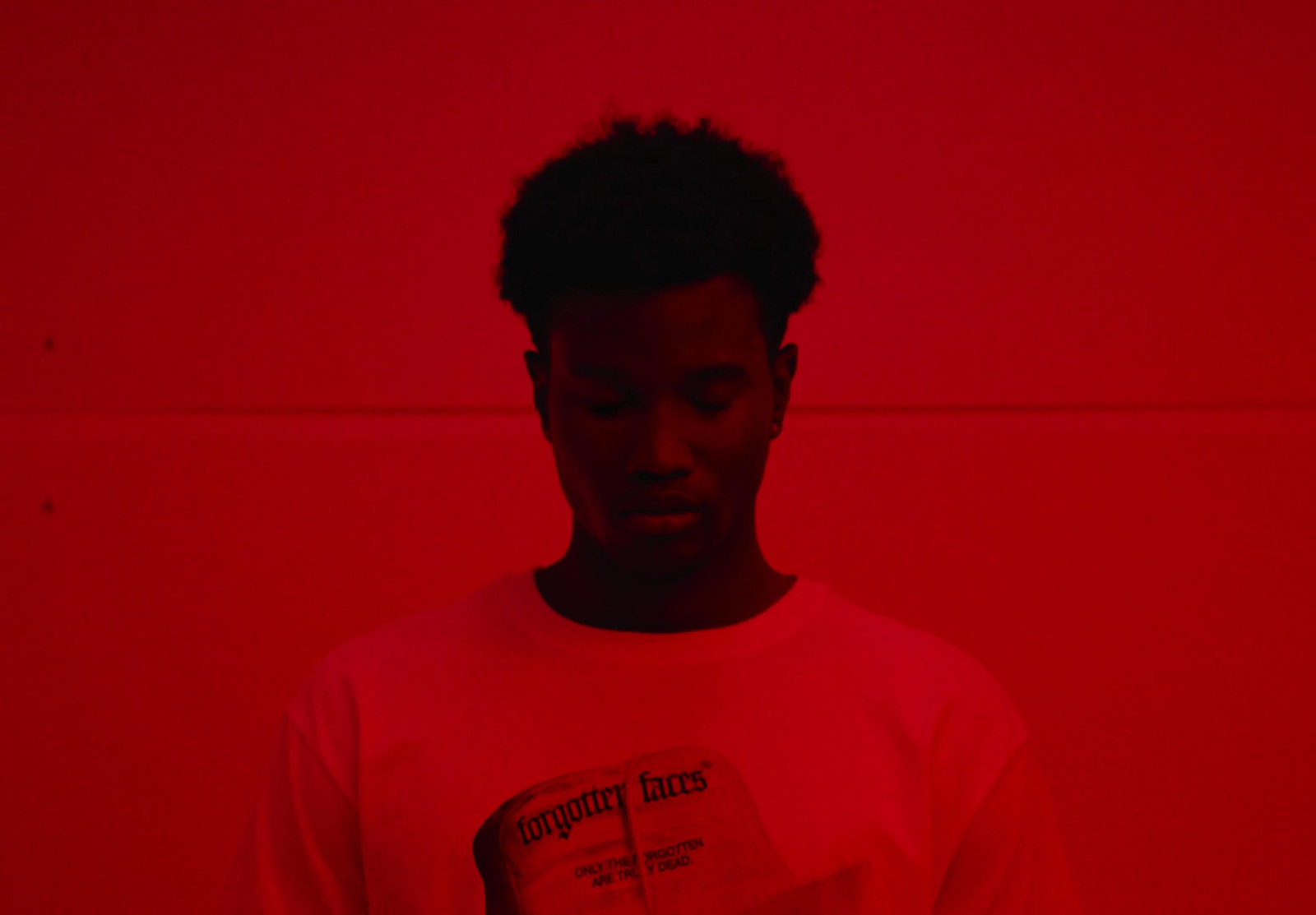 a man standing in front of a red wall