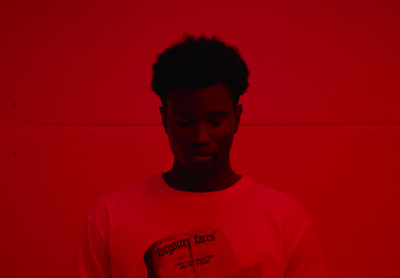 a man standing in front of a red wall