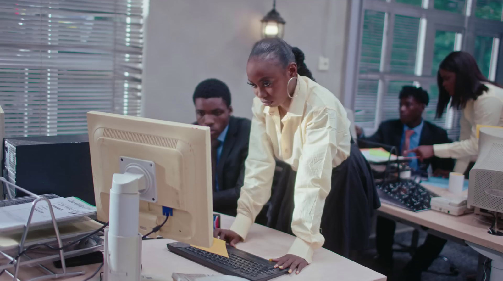 a group of people in a room working on a computer