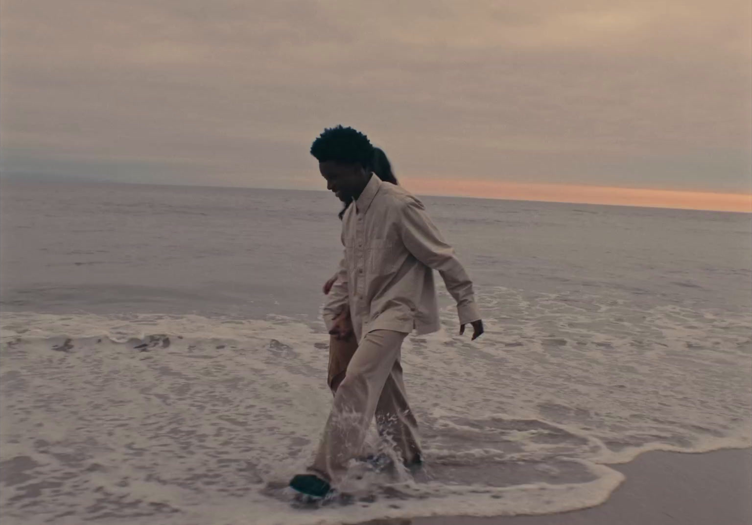 a man walking on the beach in the water