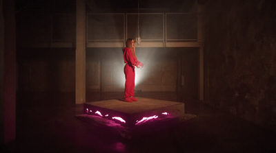 a woman in a red jumpsuit standing on a platform