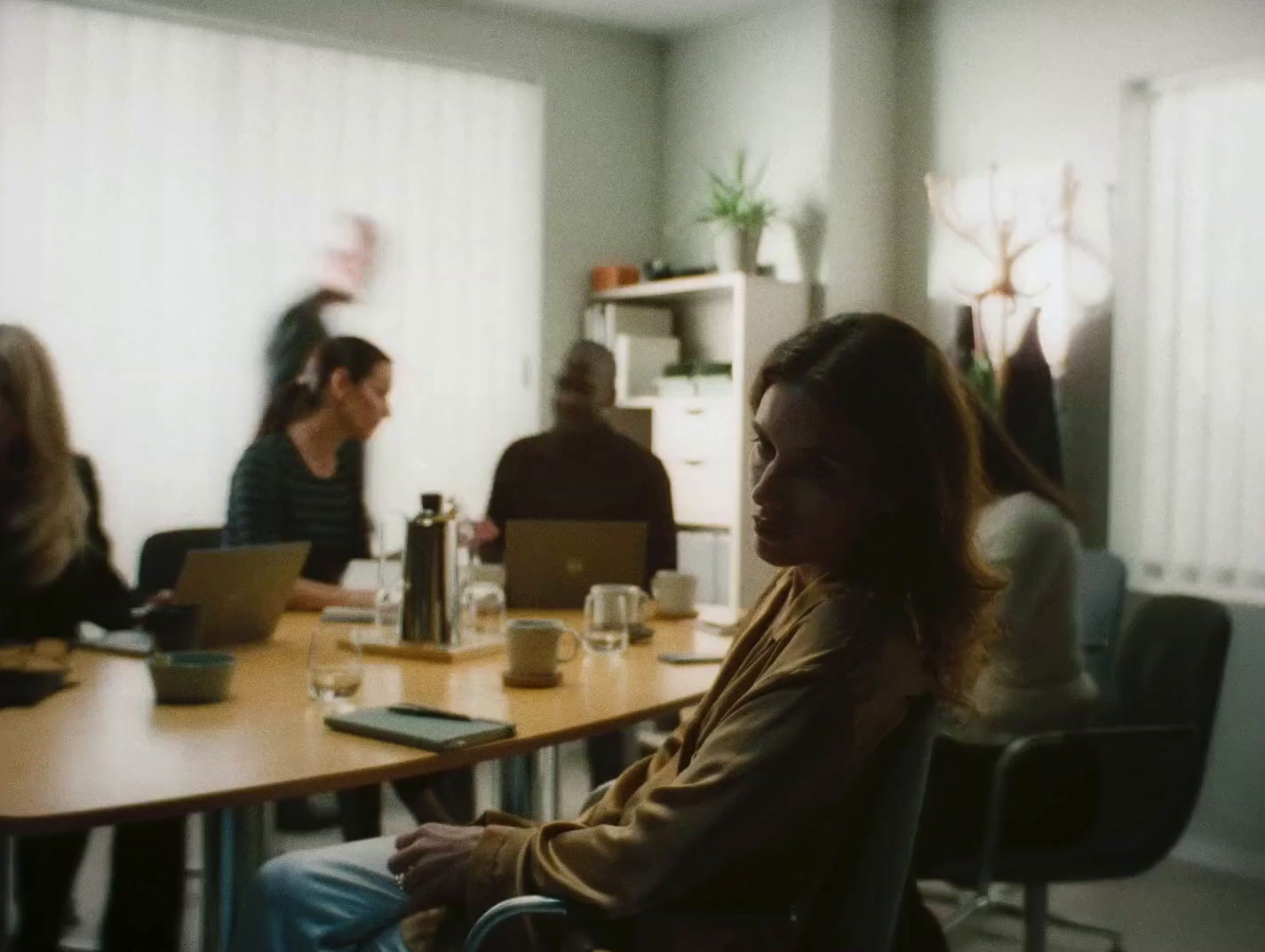 a group of people sitting around a table with laptops