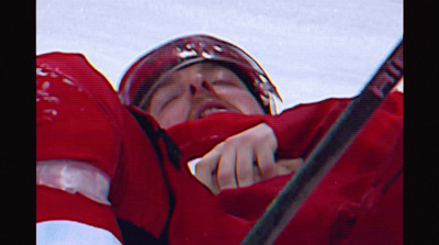 a man in a red jacket holding a hockey stick