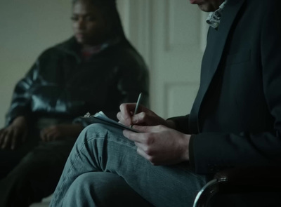 a man sitting in a chair writing on a piece of paper