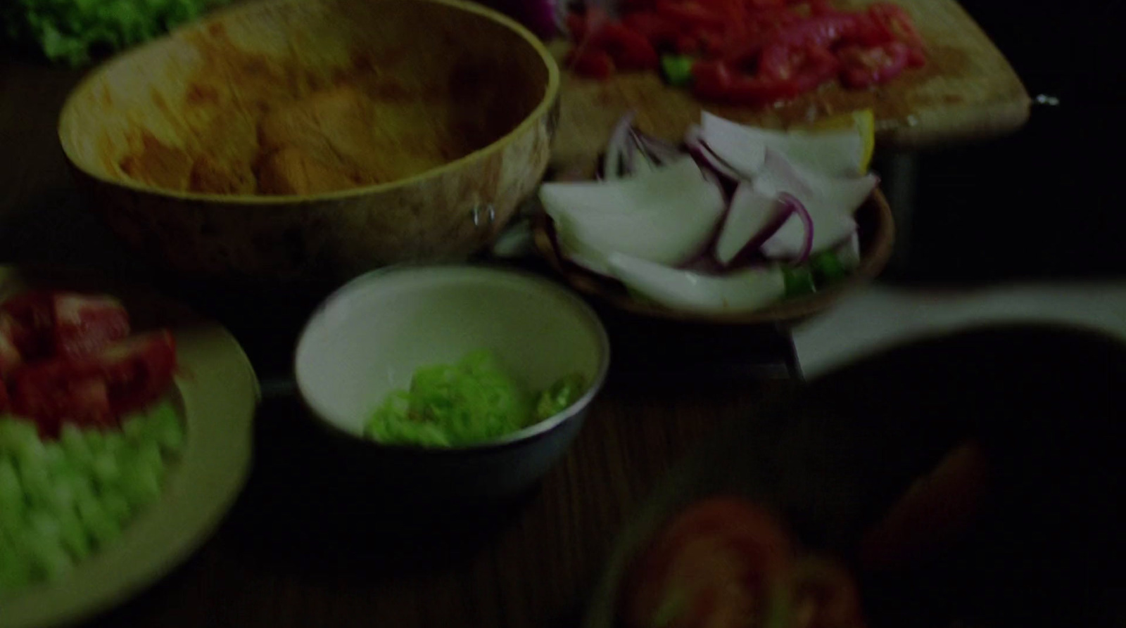 a wooden table topped with bowls filled with food