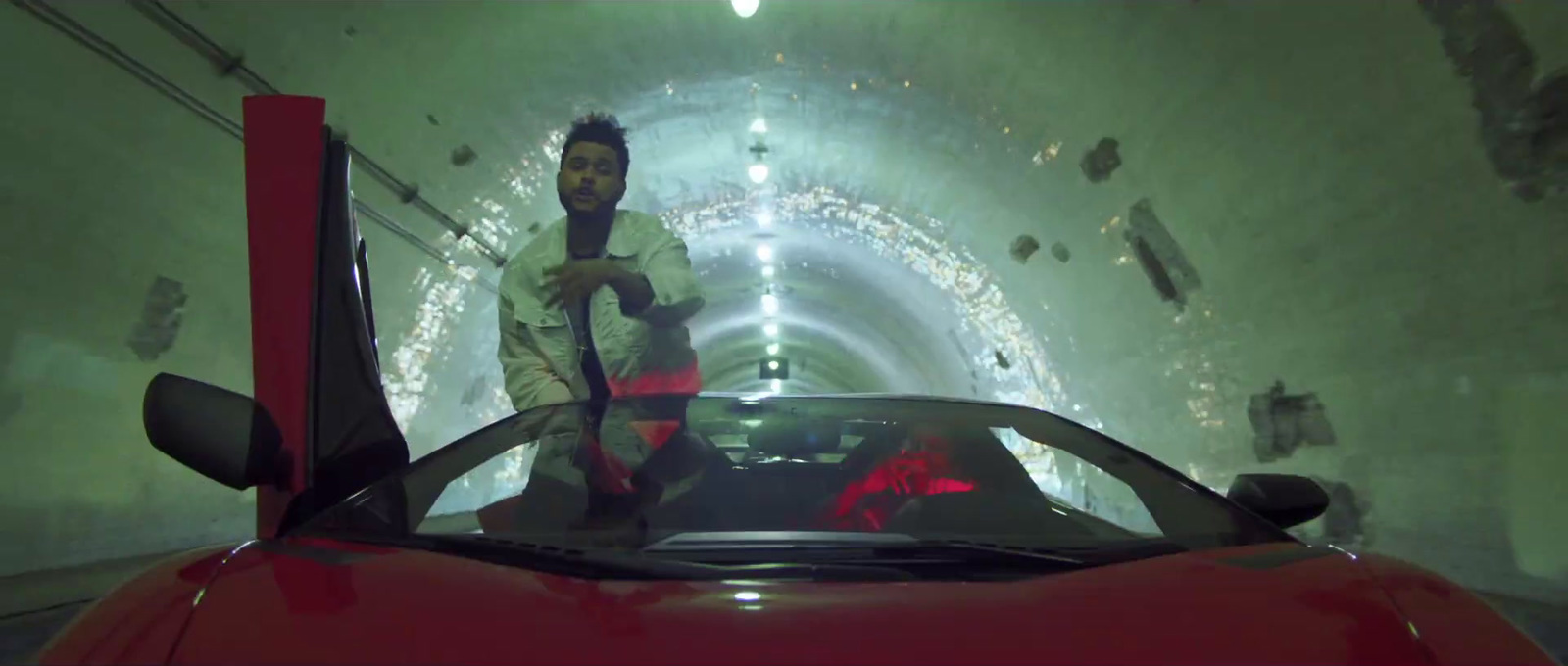 a man standing next to a red sports car