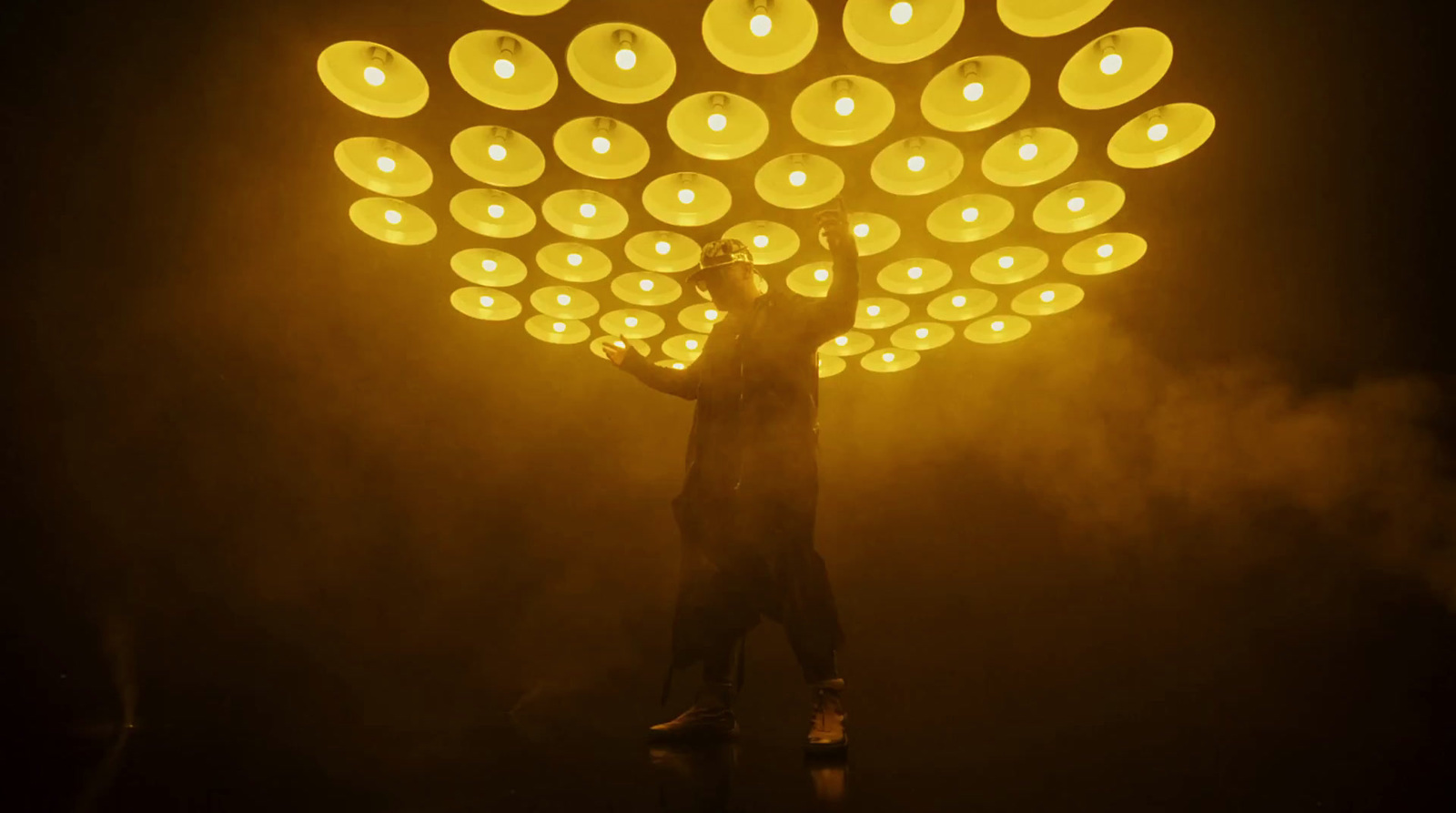 a man standing in front of a large light fixture