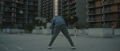 a person in a parking lot with a building in the background