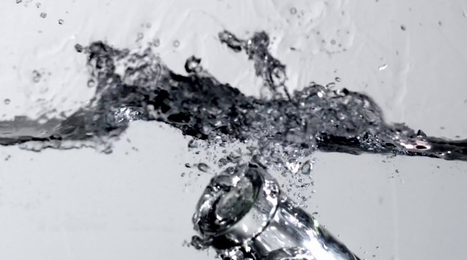 a close up of a water faucet with water splashing on it