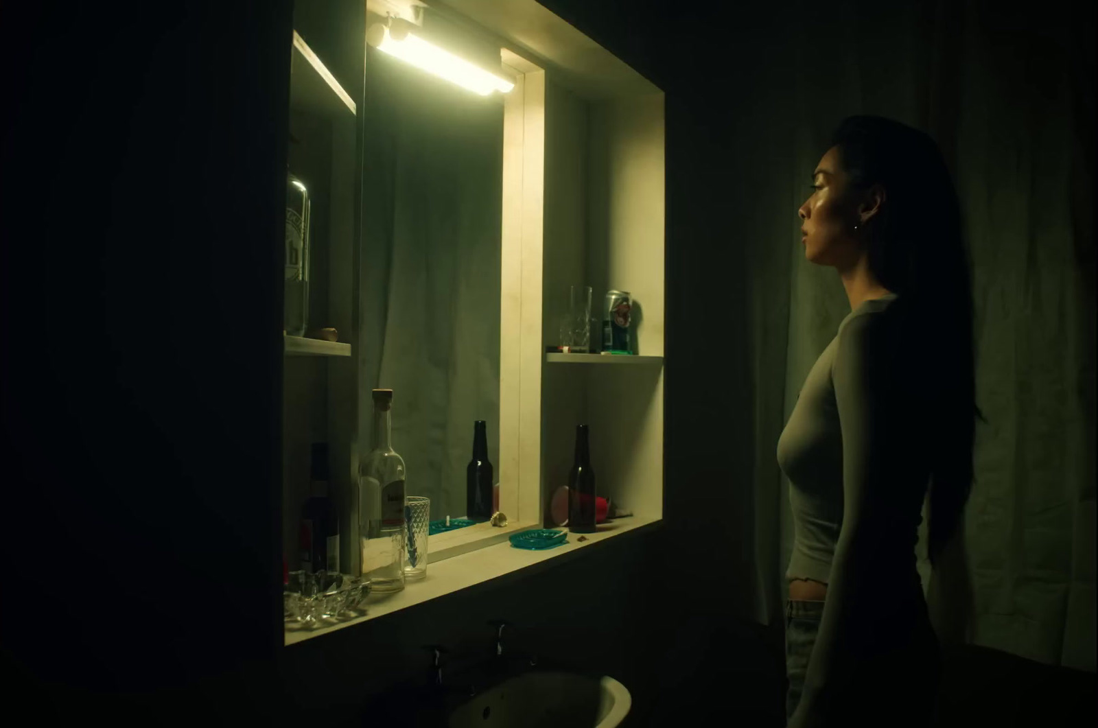 a woman standing in front of a bathroom mirror