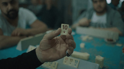 a person holding a dice in front of a group of people