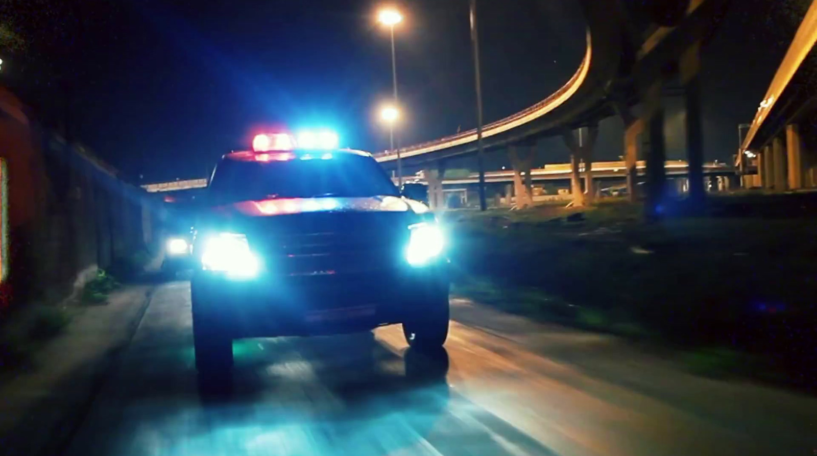 a police car driving down a street at night