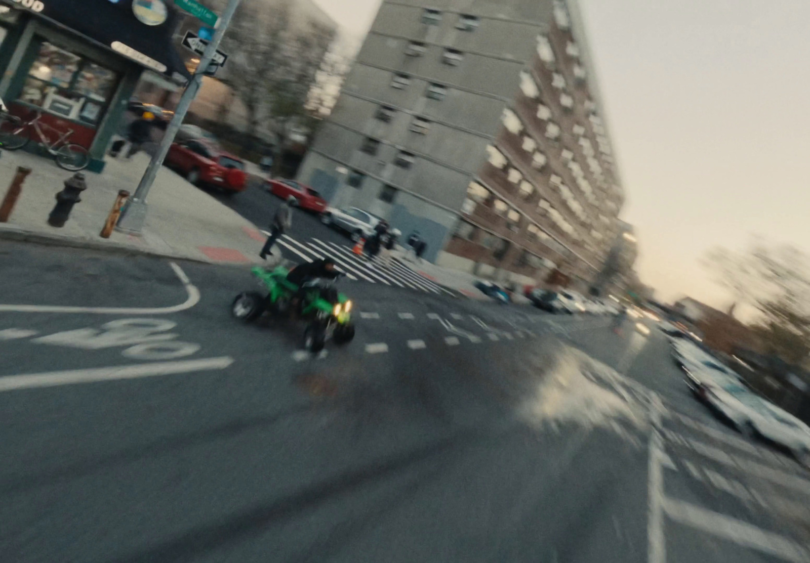 a man riding a motorcycle down a street next to tall buildings