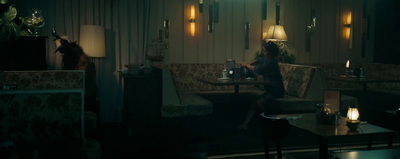 a woman sitting on a couch in a dimly lit room