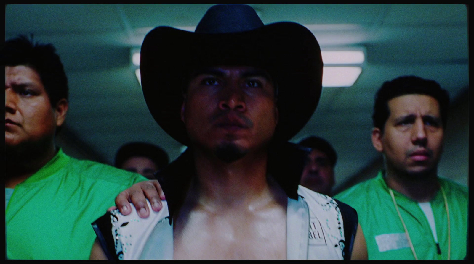 a man with a cowboy hat standing in front of other men