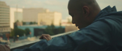 a man looking out a window at a city