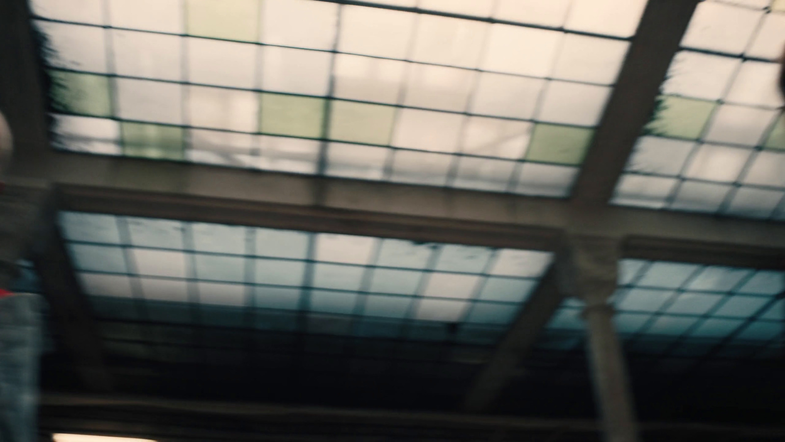 a man holding a red stop sign under a glass roof