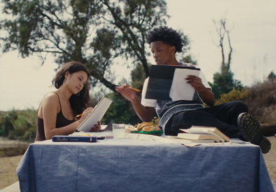 a man and a woman sitting at a table with books