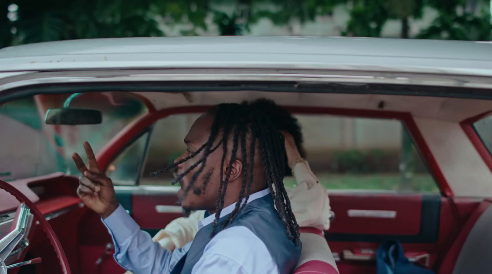 a man with dreadlocks sitting in a car