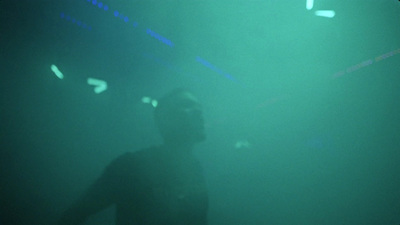 a man standing in front of a green light