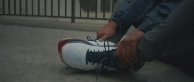 a person tying a shoelace on a pair of shoes