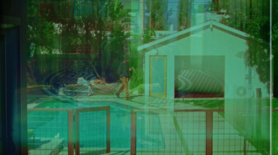 a blurry photo of a pool with a house in the background