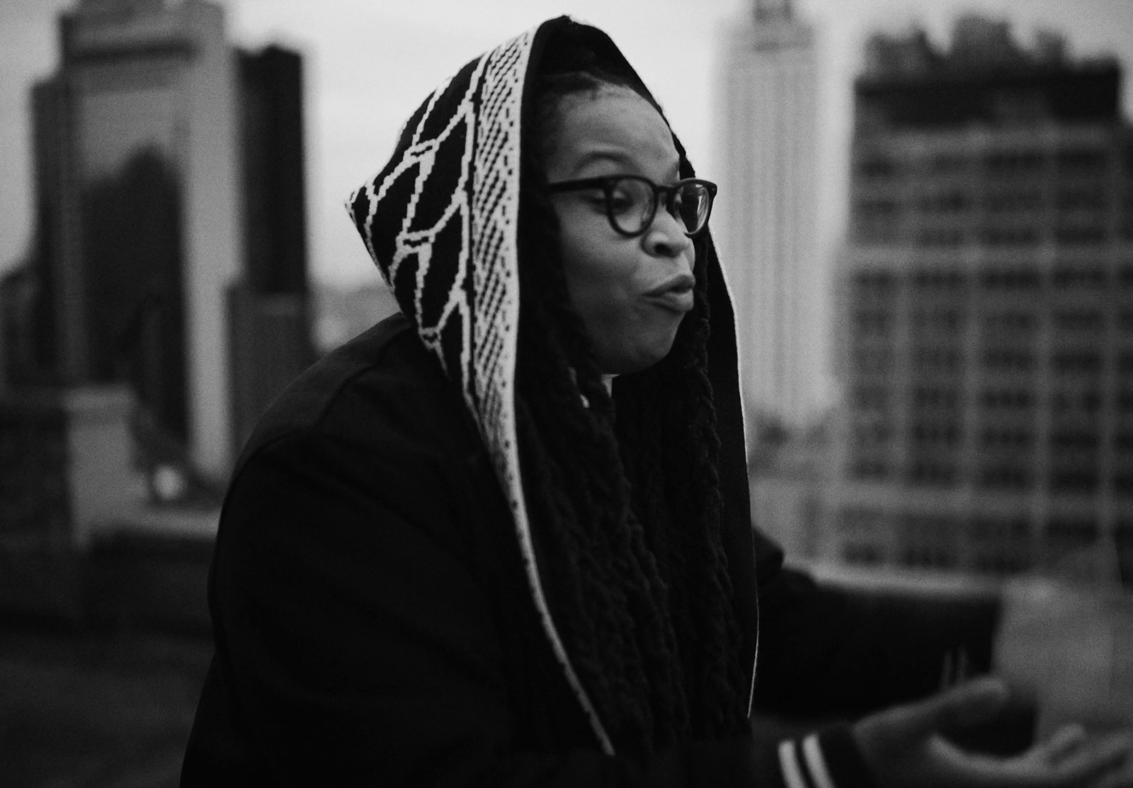 a black and white photo of a woman wearing a hoodie