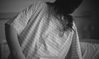 a woman in a hospital gown standing in a bed