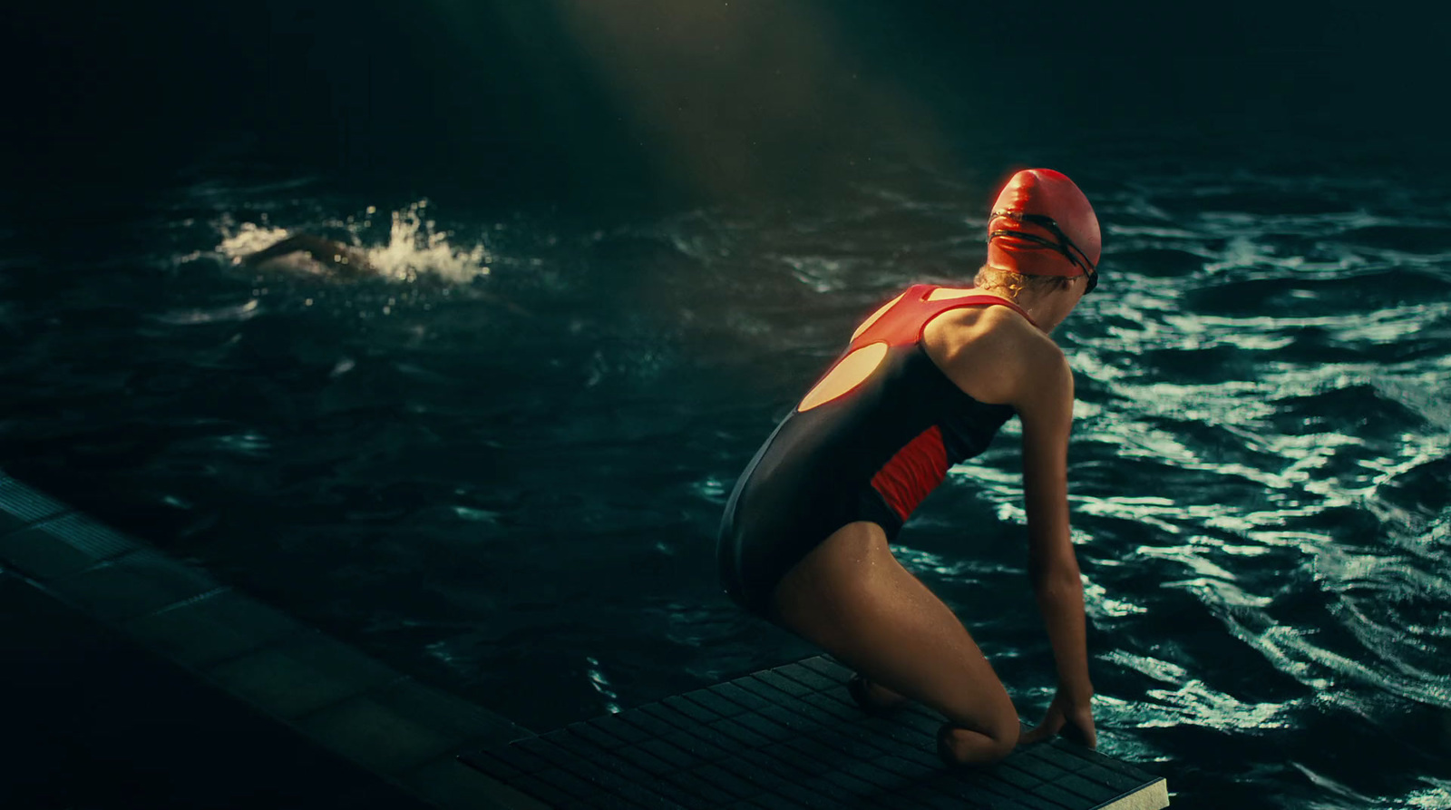 a woman in a bathing suit sitting on a dock