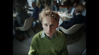 a man in a green shirt sitting at a table