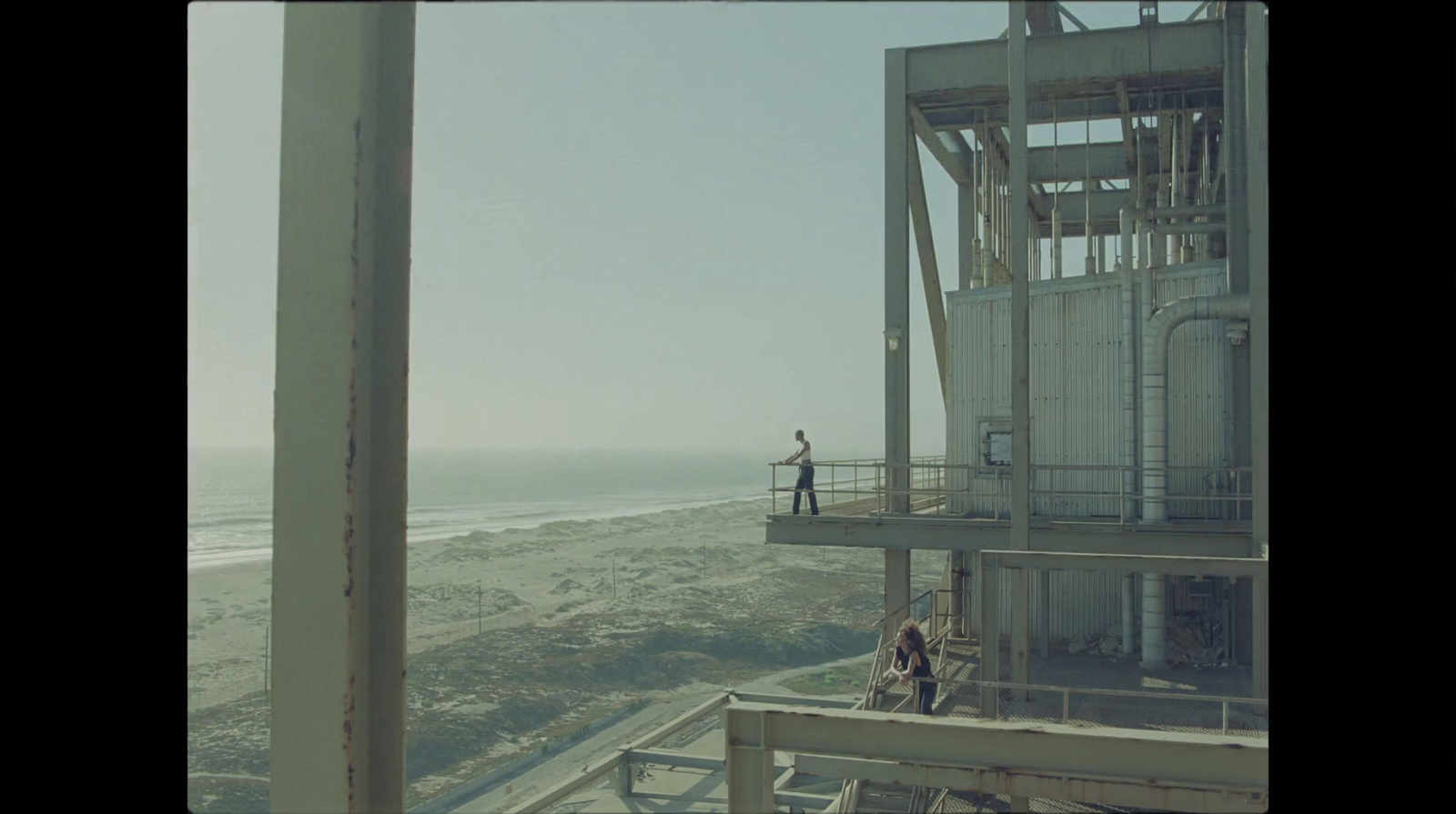 a couple of people standing on top of a tall building