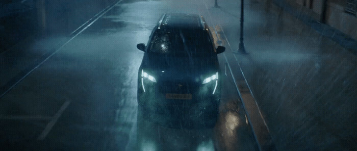 a car driving down a street in the rain