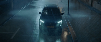 a car driving down a street in the rain