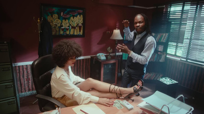 a woman sitting at a desk talking to another woman