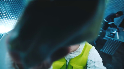 a woman in a yellow vest is looking at her cell phone