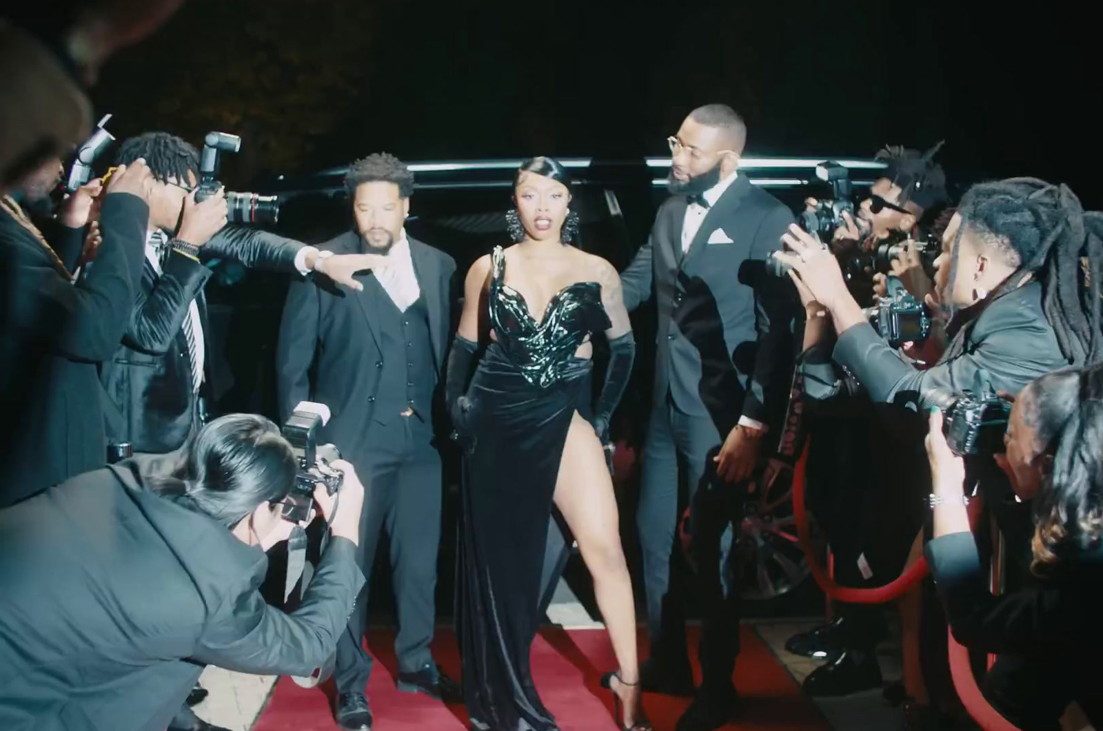 a group of people standing around a woman in a black dress